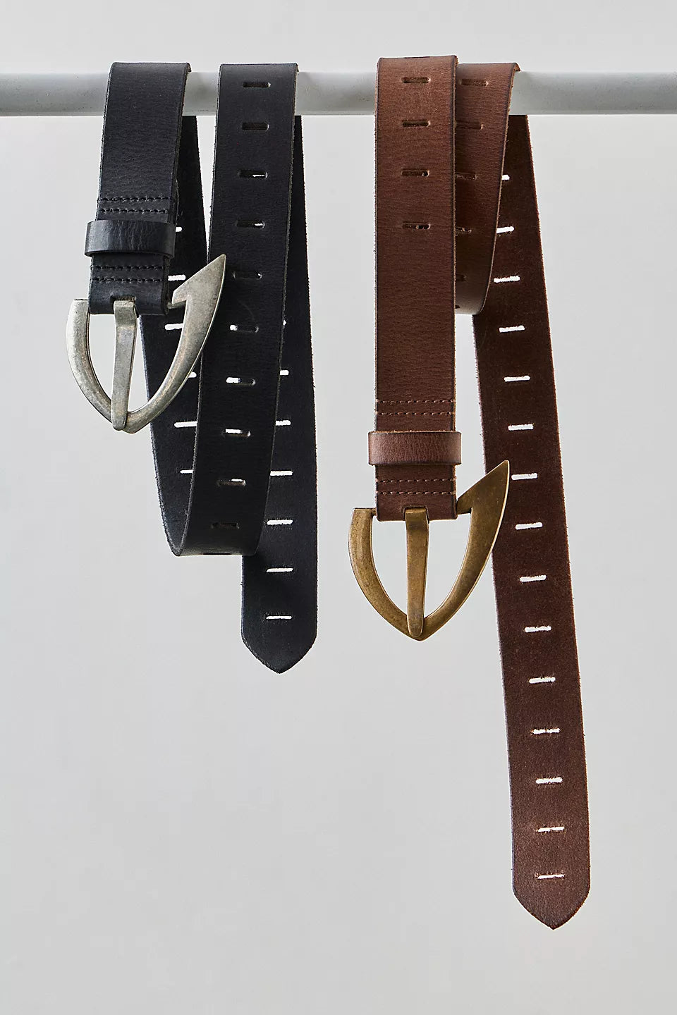 We The Free Noa Belt in black and cognac hanging on a bar