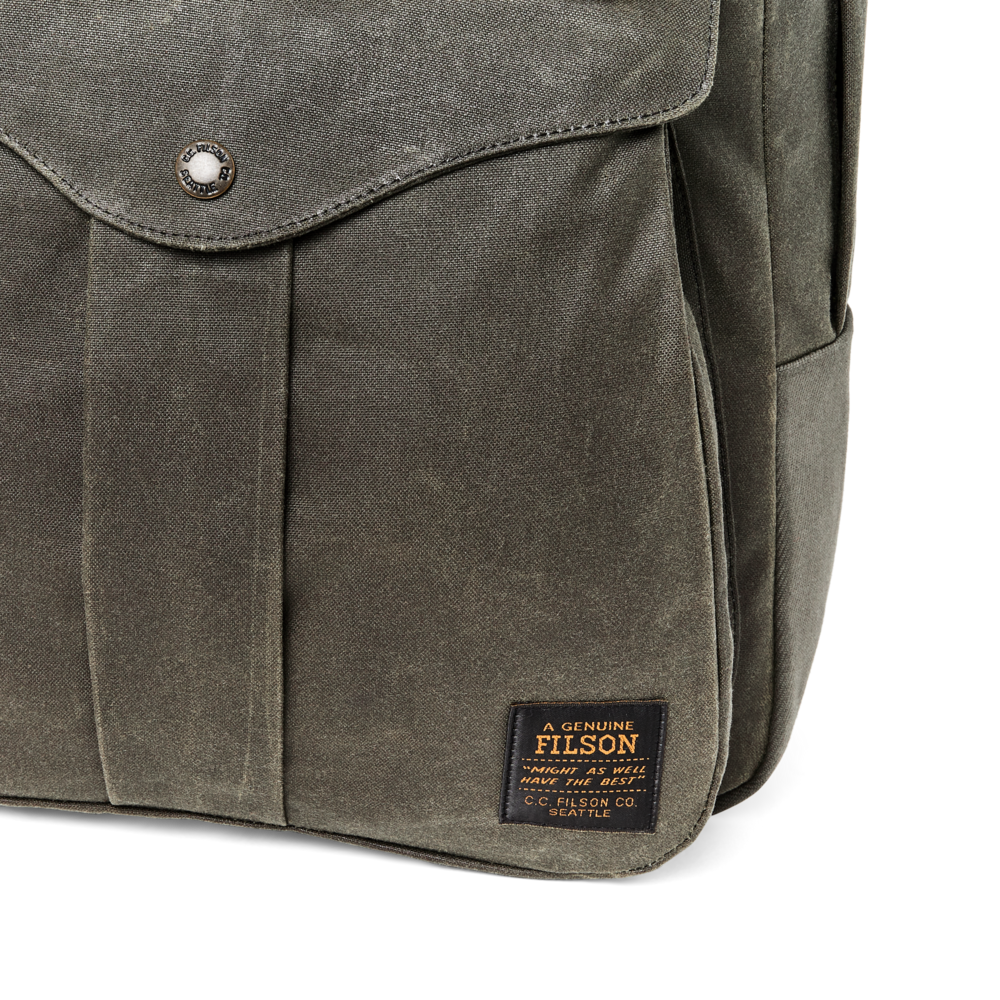 Brown waxed canvas backpack with Filson label on a white background
