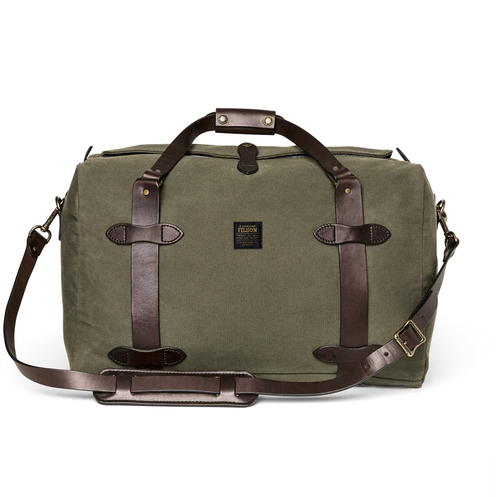 An olive green canvas duffel bag with dark brown leather straps, handles, and a detachable shoulder strap, shown on a plain white background.