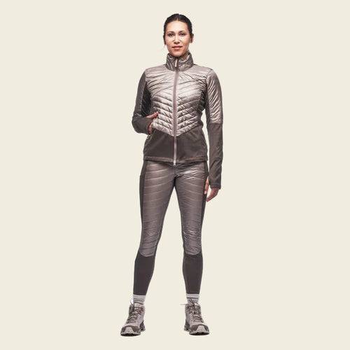 Woman wearing a gray insulated jacket and pants on a white background