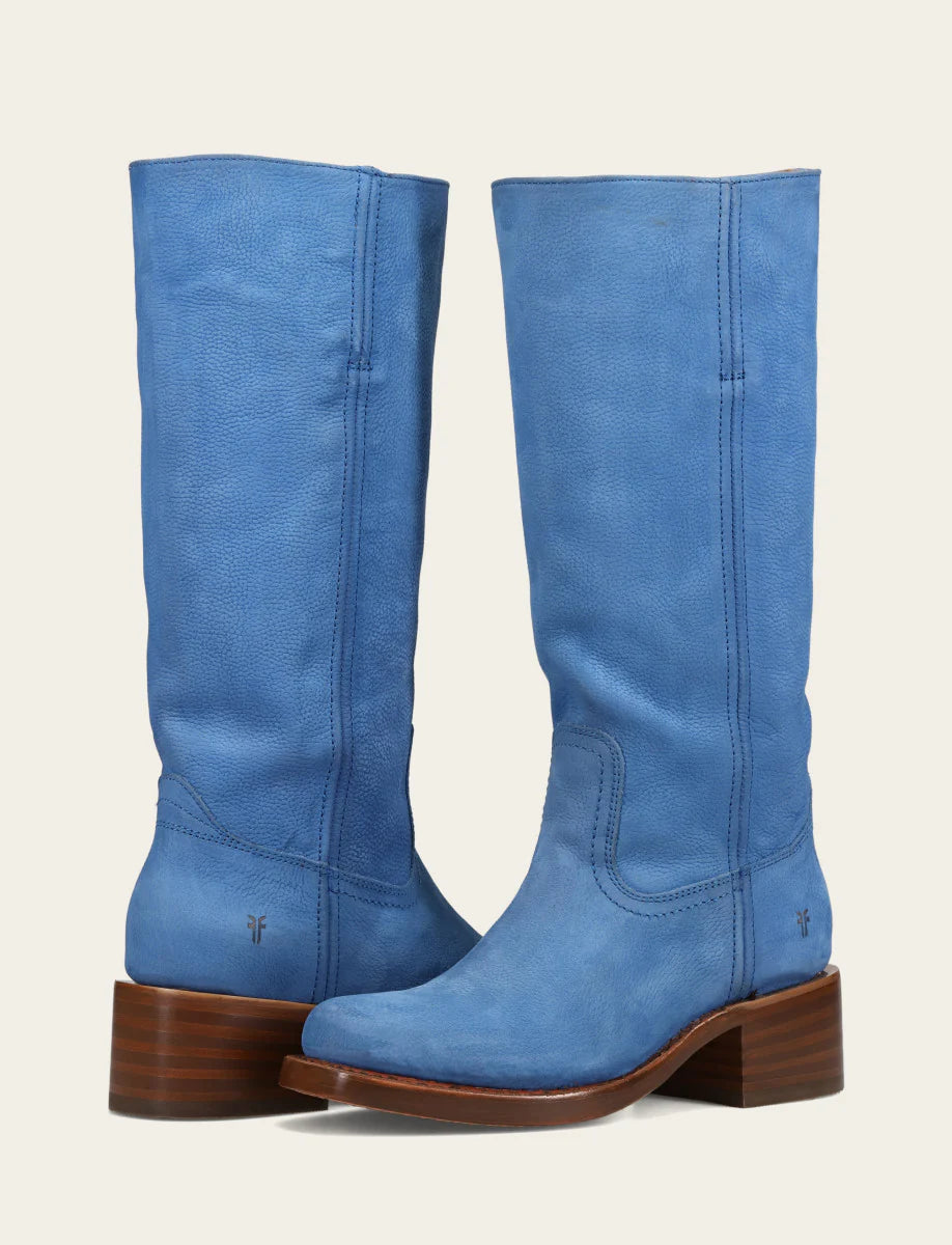Pair of blue knee-high boots with brown soles on a light gray background