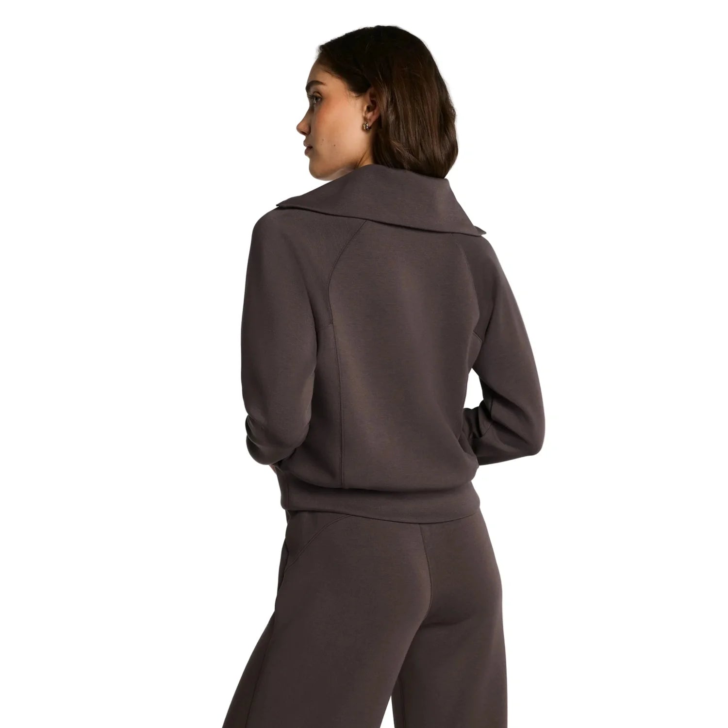 Woman wearing a brown tracksuit on a white background