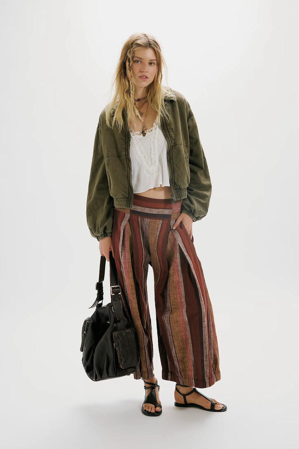 Woman wearing a green jacket and patterned skirt on a white background