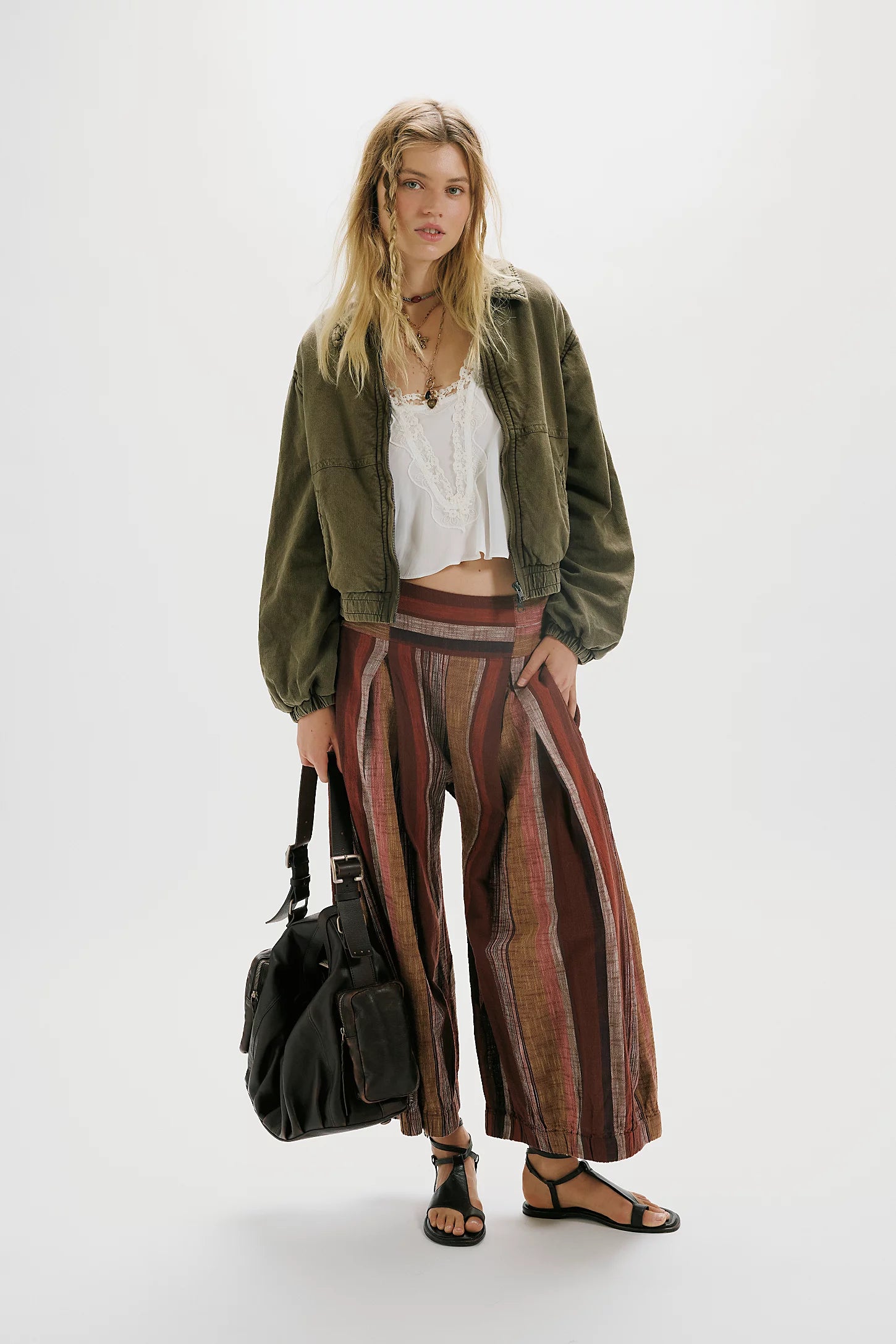 Woman wearing a green jacket and patterned skirt on a white background