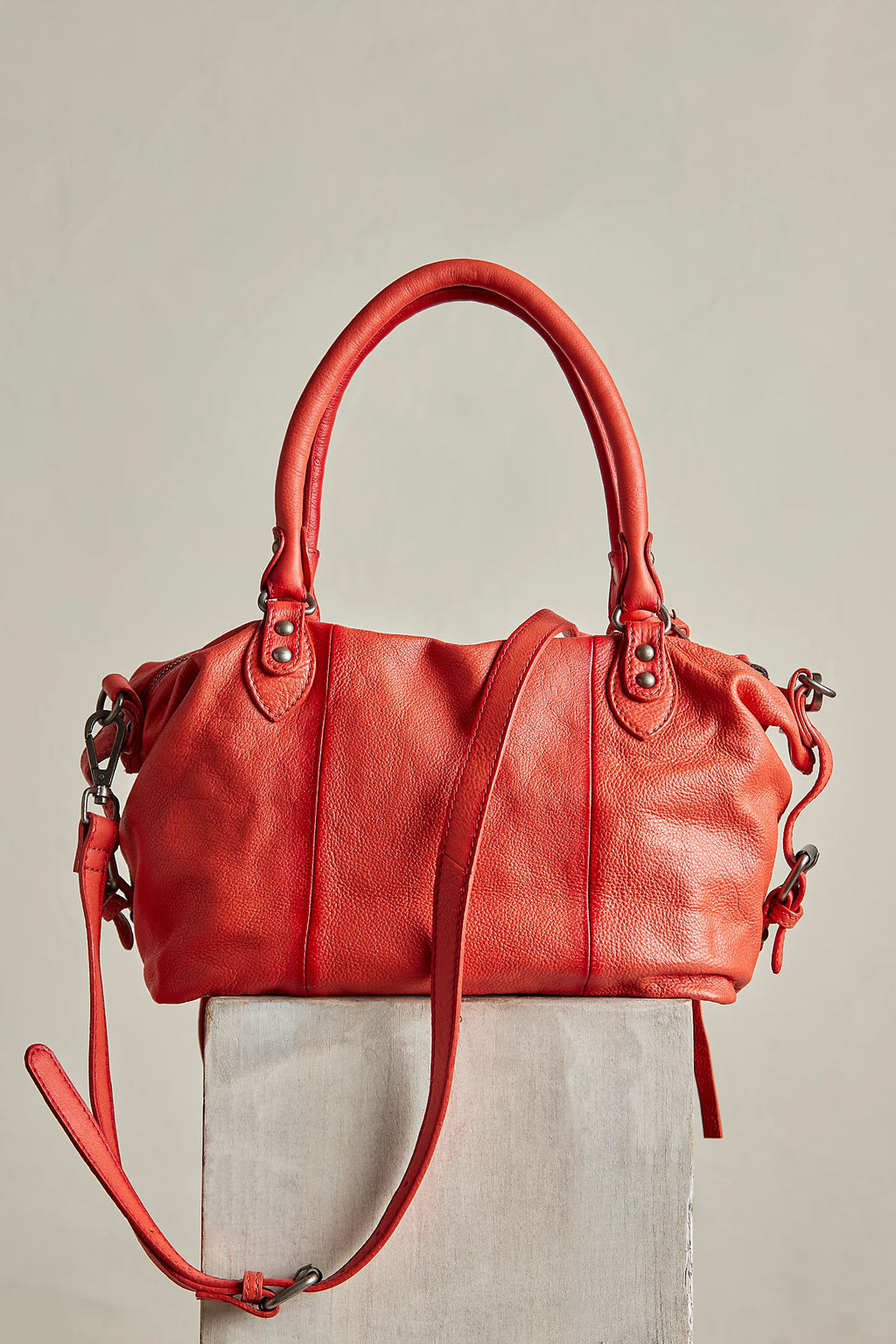 Red leather handbag on a light gray background