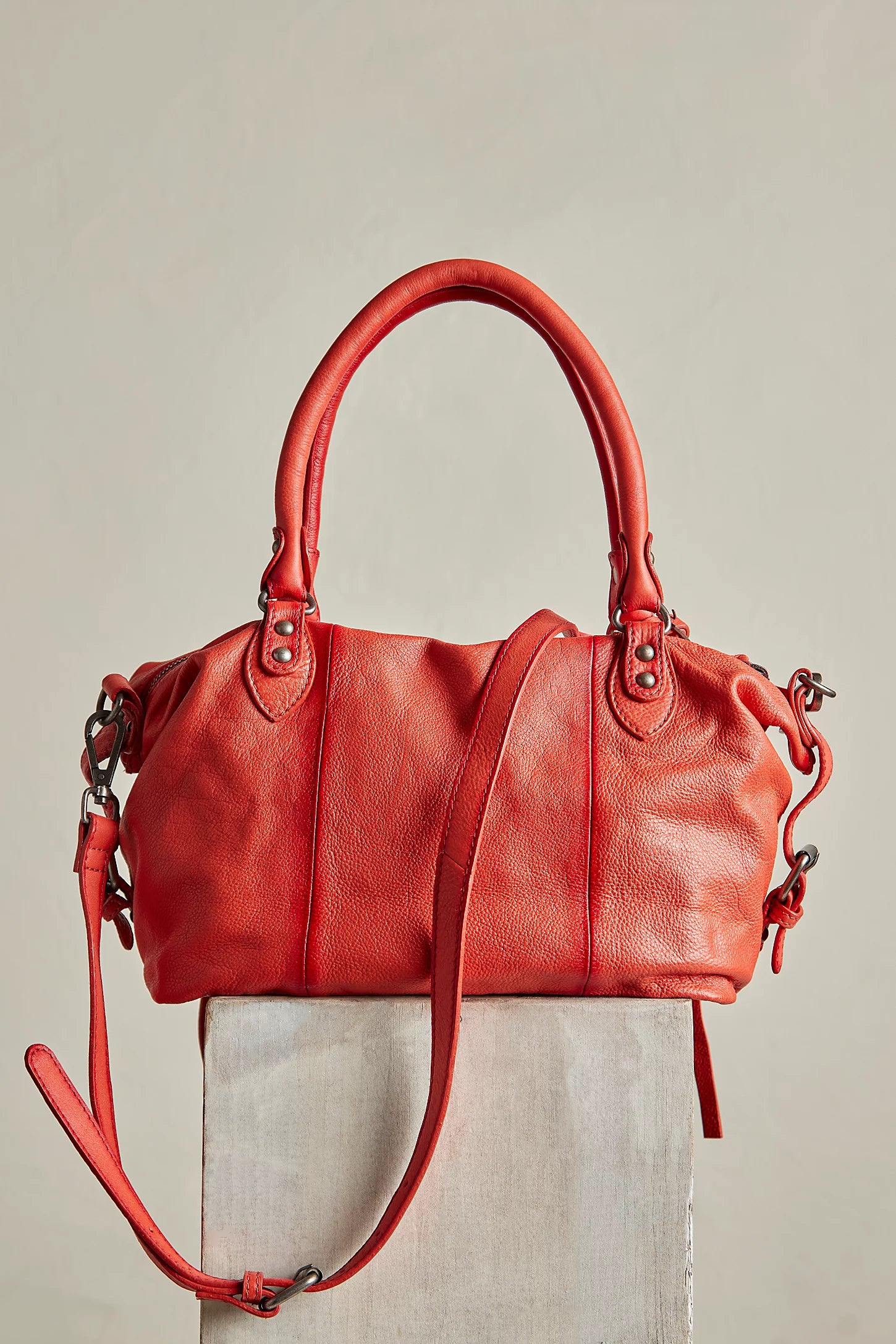 Red leather handbag on a light gray background