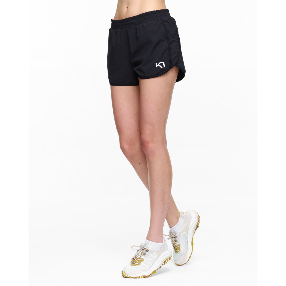Black athletic shorts with a logo worn by a person on a white background