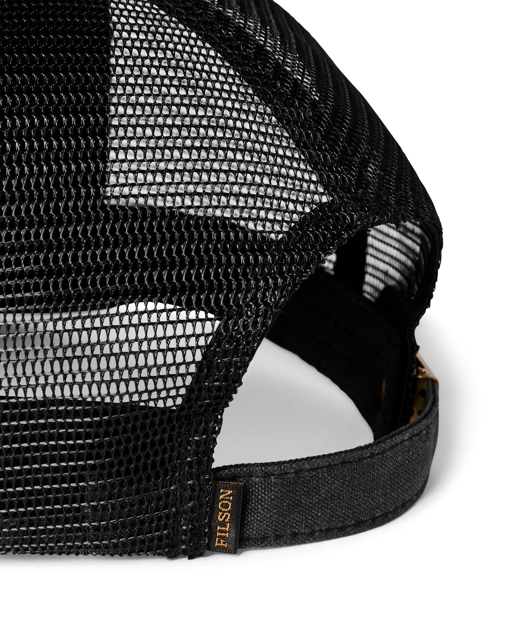 Close-up of a black mesh trucker cap showing the back panels, adjustable strap, and a small FILSON brand tag on the side.