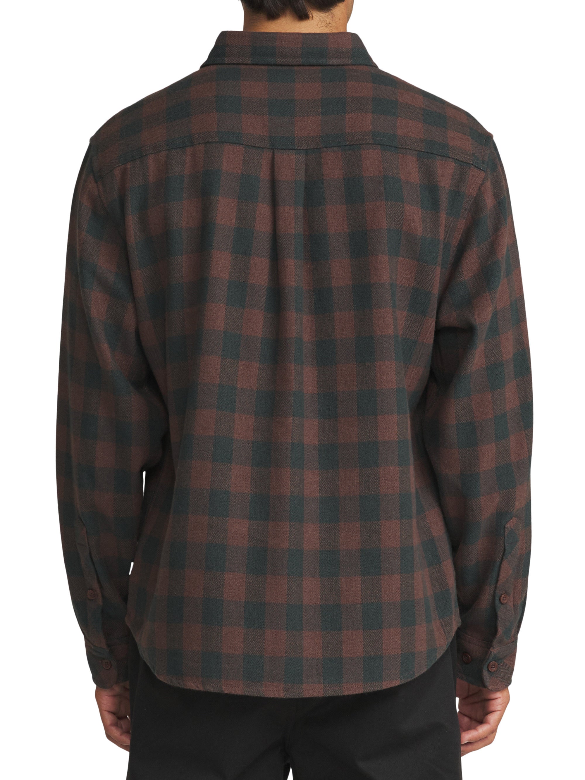 A man viewed from the back wearing a long-sleeve plaid flannel shirt in dark brown and black, paired with black pants, against a plain white background.