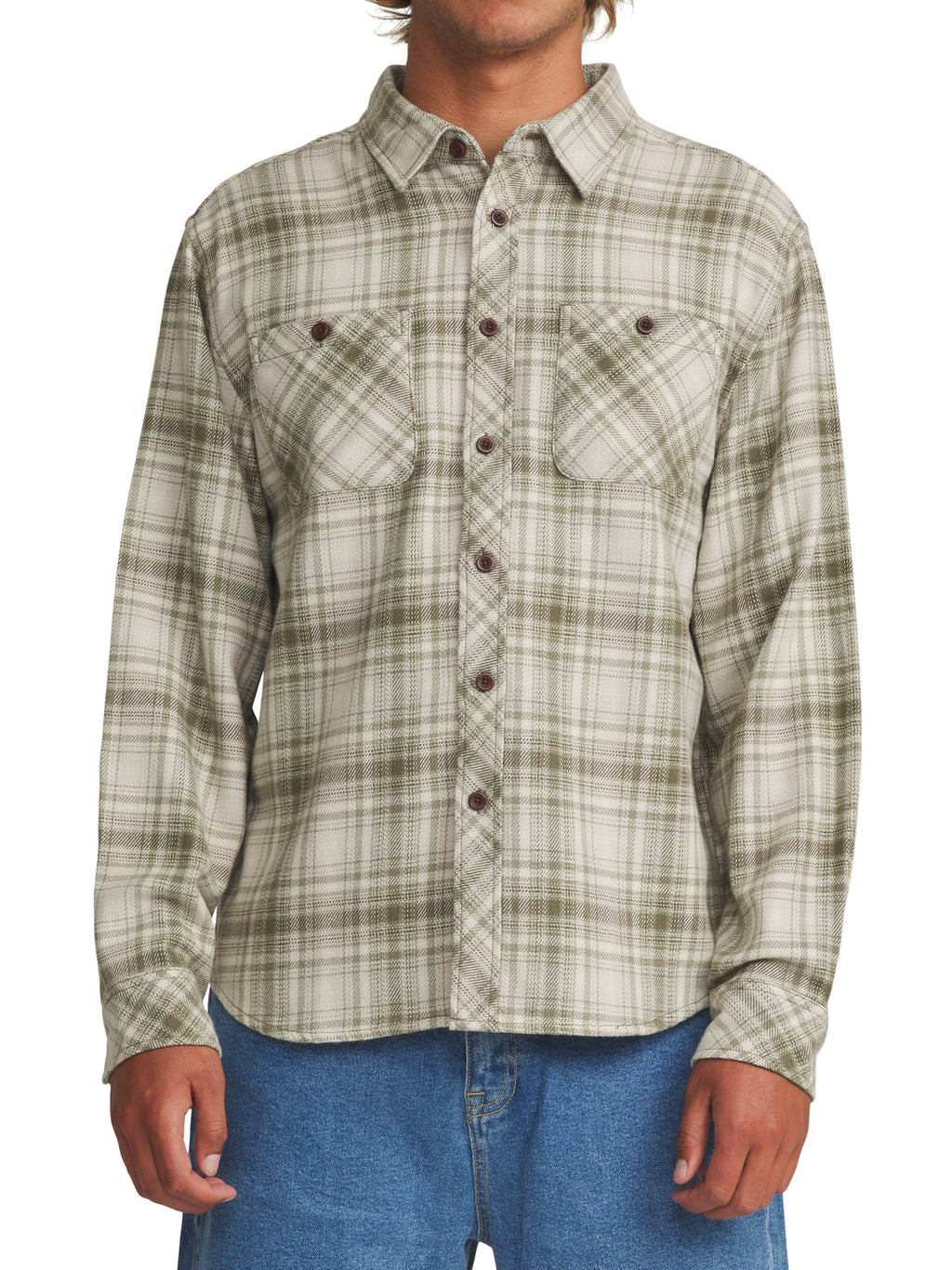 A man wearing a long-sleeve button-up flannel shirt with a green and beige plaid pattern, paired with blue jeans, shown against a plain white background.