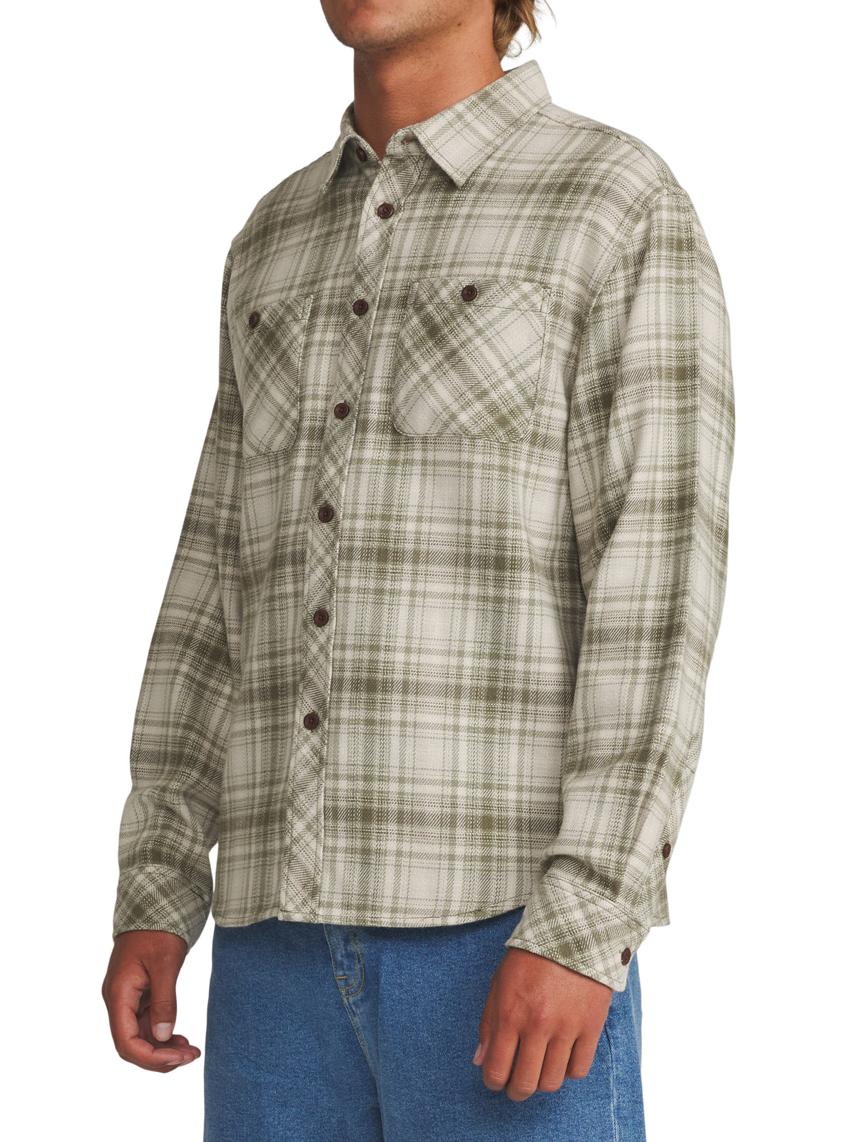 A man wearing a long-sleeve plaid button-up shirt in sage green and beige, paired with blue jeans, shown from the waist up against a white background.