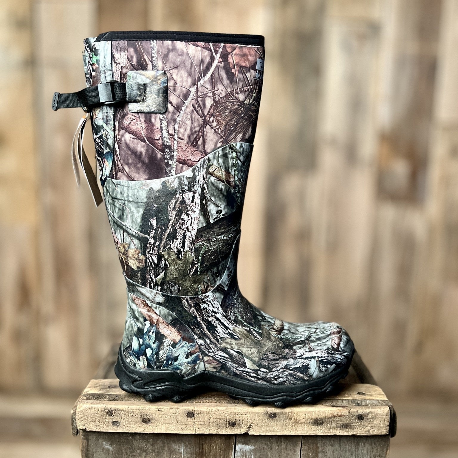 Camouflage-patterned boot on a wooden block with a wooden background.