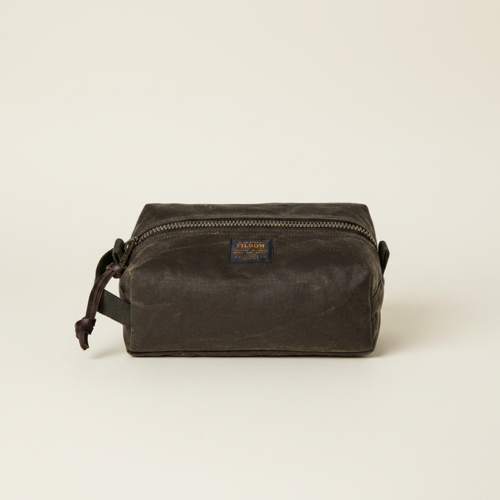 Brown waxed canvas dopp kit with Filson logo on a white background