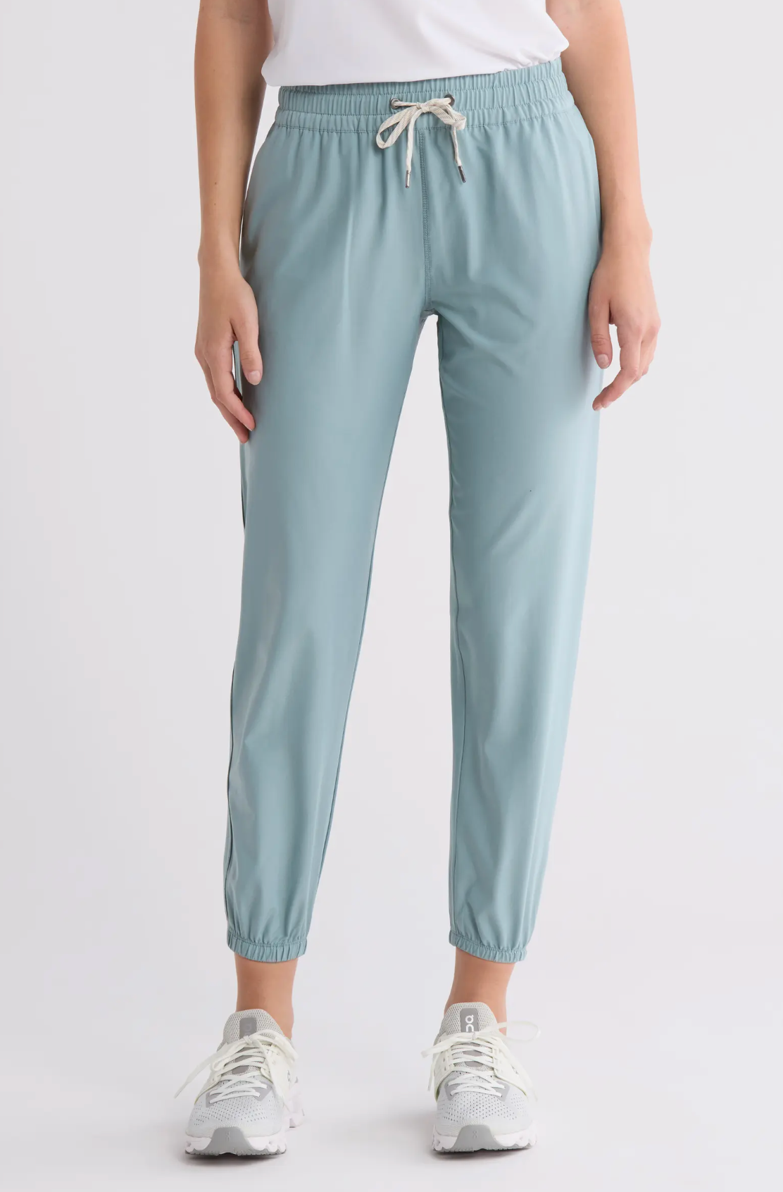 Light blue jogger pants worn by a person on a white background